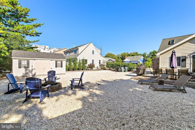 view of yard featuring an outdoor fire pit, a patio area, and a shed