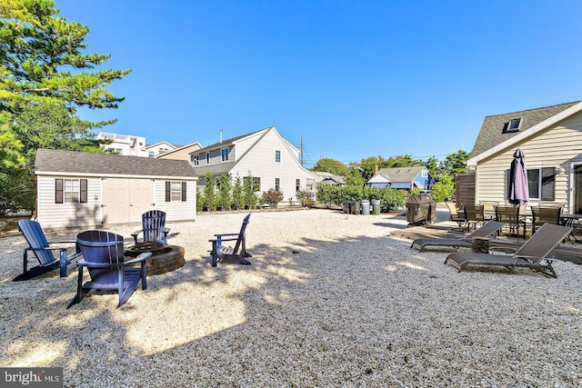 view of yard featuring a patio, an outbuilding, and a fire pit