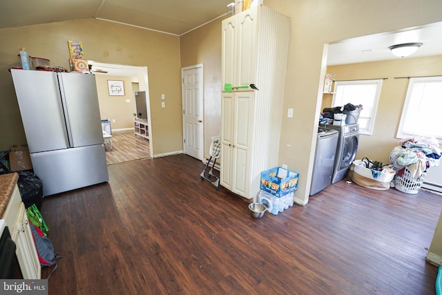 kitchen with hardwood / wood-style flooring, white fridge, vaulted ceiling, white cabinetry, and independent washer and dryer