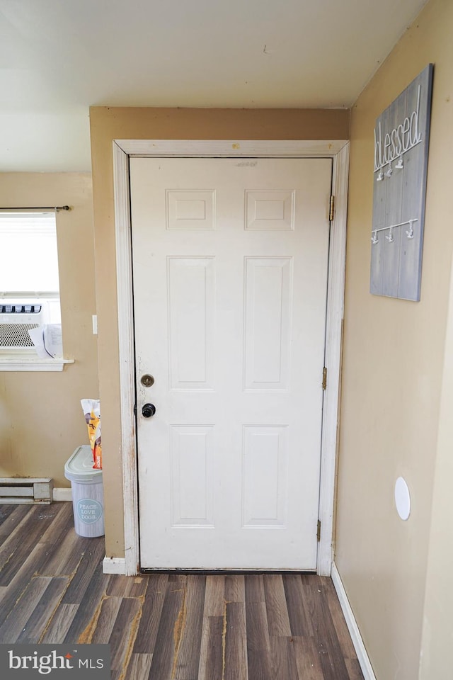 entrance foyer featuring cooling unit, dark wood-type flooring, and a baseboard radiator