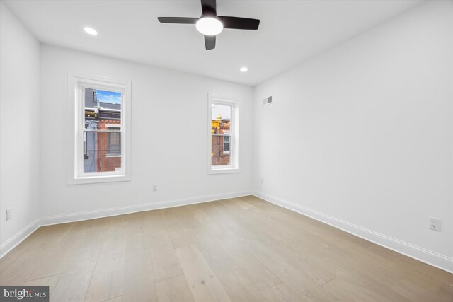 unfurnished living room featuring beamed ceiling, heating unit, and light hardwood / wood-style flooring