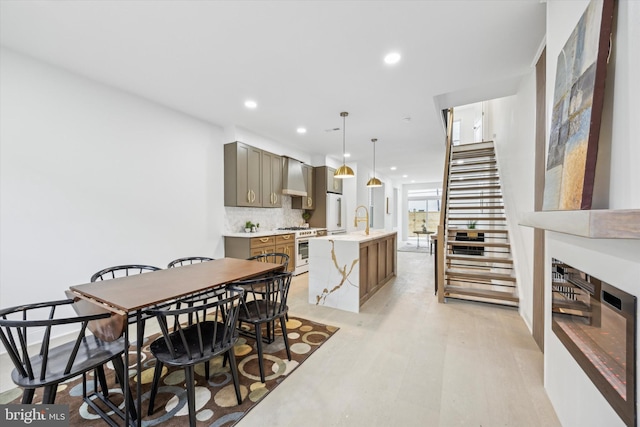 dining area with recessed lighting, light wood-type flooring, and stairs