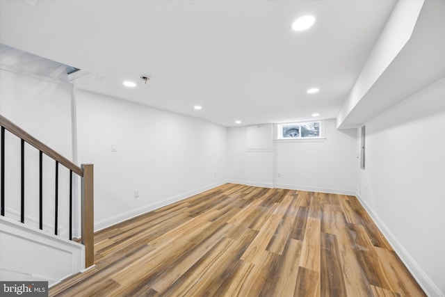 basement featuring recessed lighting, stairway, and wood finished floors