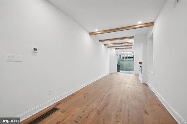 hall with beamed ceiling and light hardwood / wood-style flooring