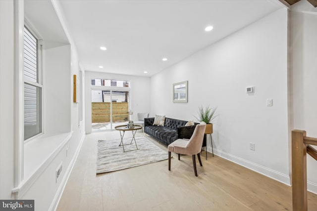 living area with recessed lighting, baseboards, and wood finished floors