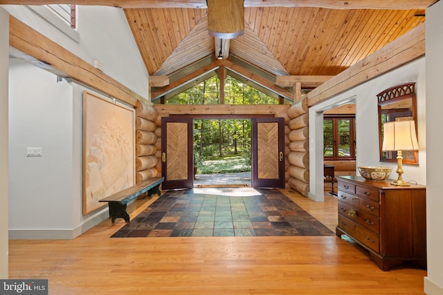 foyer entrance with beamed ceiling, log walls, wooden ceiling, and baseboards