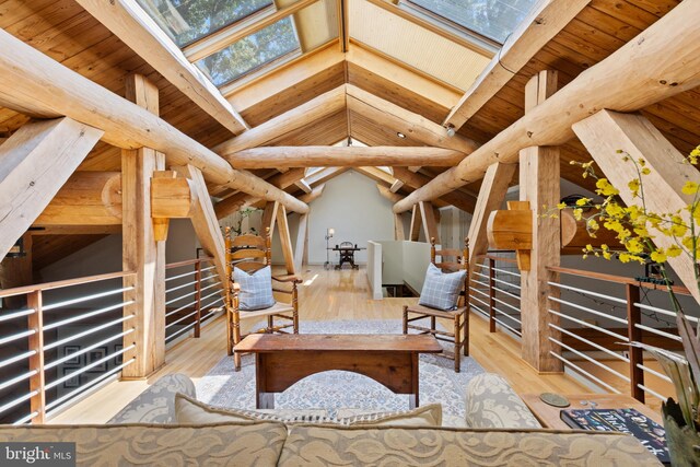 interior space featuring wood finished floors and lofted ceiling with skylight