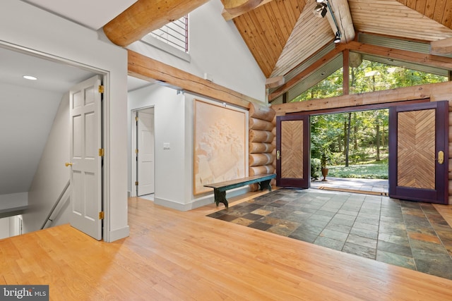 interior space featuring high vaulted ceiling, baseboards, and beamed ceiling
