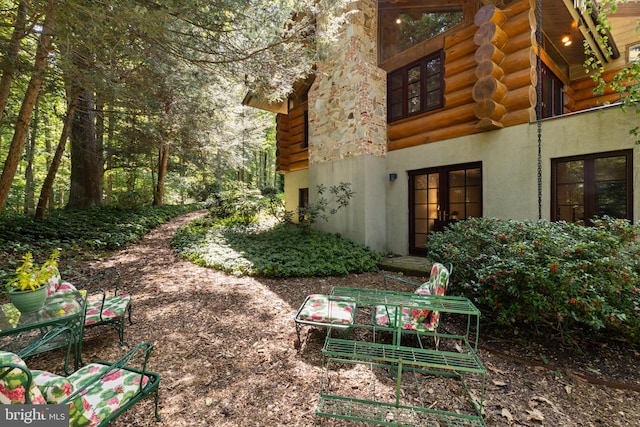 view of side of property with stucco siding and log exterior