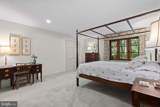 bedroom with baseboards and light carpet