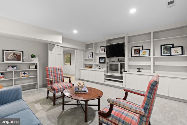 living area featuring visible vents, recessed lighting, and light colored carpet