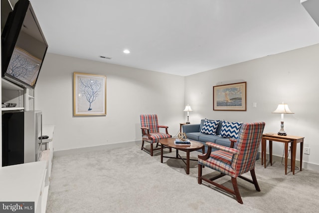 carpeted living area featuring visible vents, baseboards, and recessed lighting