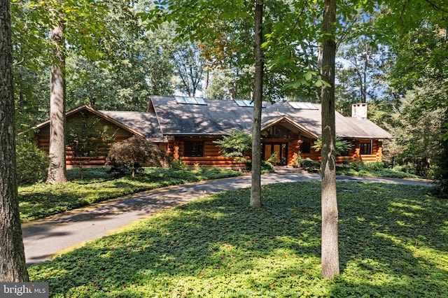 log home with a front yard, driveway, and log siding