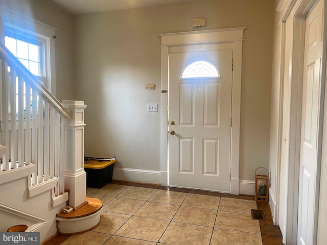 tiled entrance foyer featuring a healthy amount of sunlight