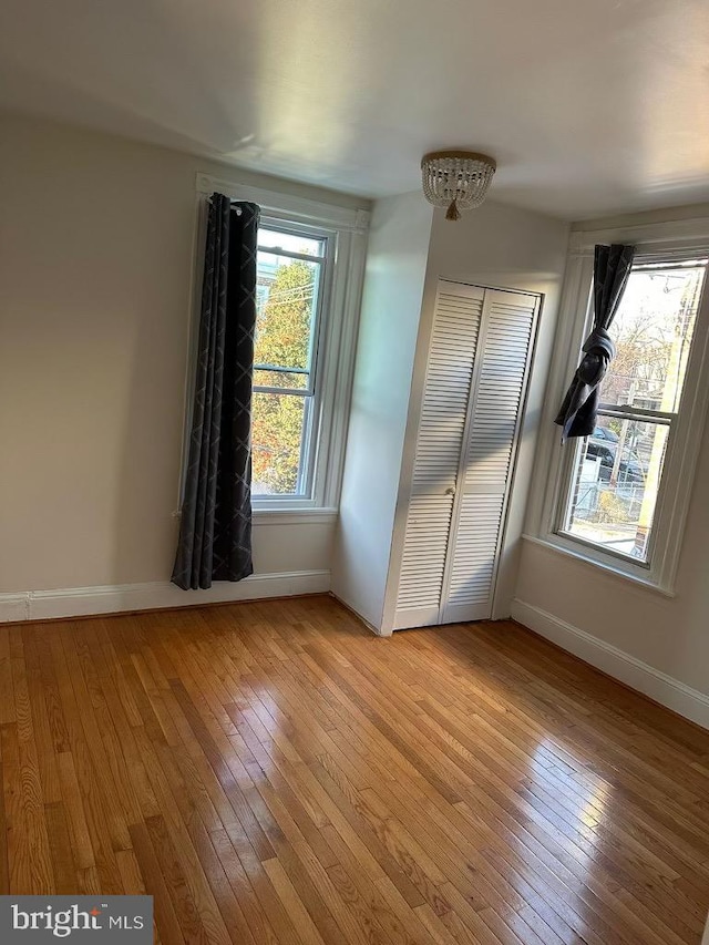 unfurnished bedroom featuring light wood-type flooring and a closet