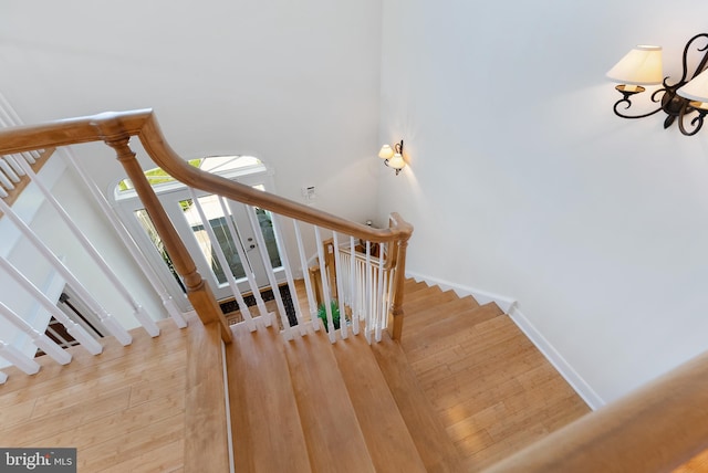 staircase with hardwood / wood-style flooring and a towering ceiling