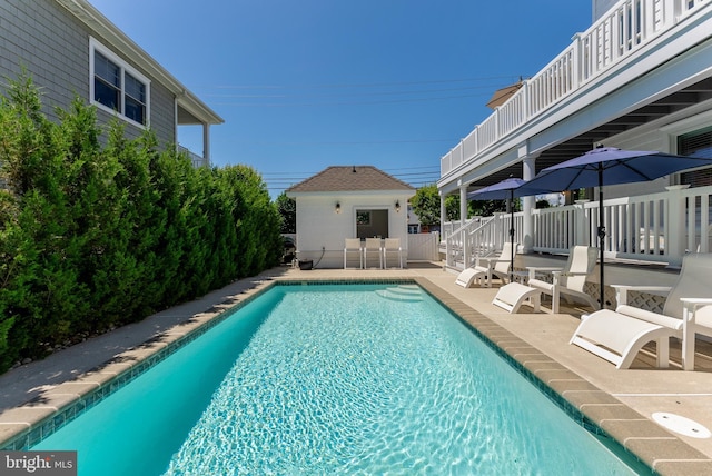 view of swimming pool featuring an outbuilding and a patio area