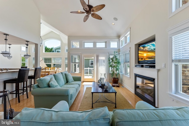 sunroom / solarium with ceiling fan, vaulted ceiling, and a healthy amount of sunlight