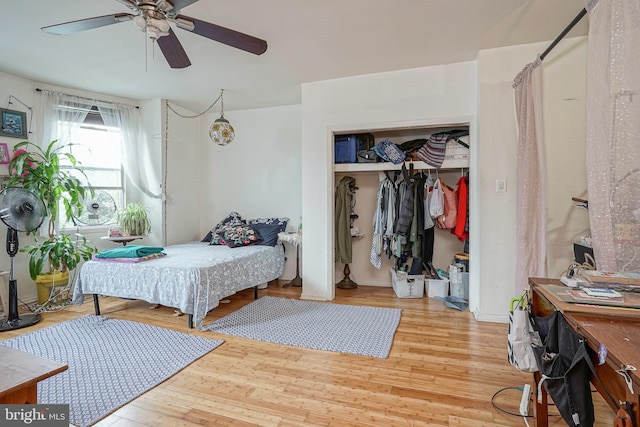 bedroom featuring ceiling fan, light wood-type flooring, and a closet