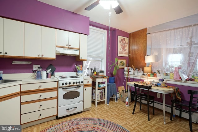 kitchen with high end range, ceiling fan, white cabinets, and light parquet floors