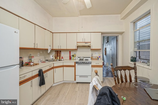 kitchen featuring sink, light hardwood / wood-style flooring, white appliances, ceiling fan, and white cabinets