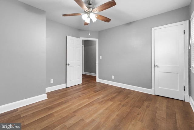 unfurnished bedroom with a ceiling fan, baseboards, and wood finished floors