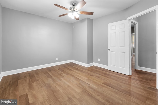 unfurnished room with ceiling fan, baseboards, and wood finished floors