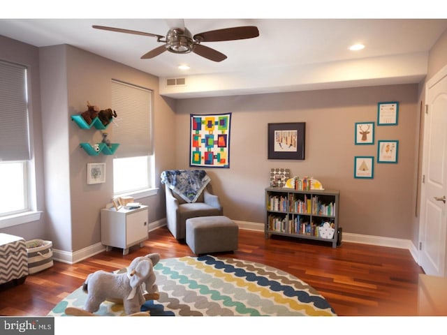 sitting room featuring ceiling fan, a wealth of natural light, and hardwood / wood-style flooring