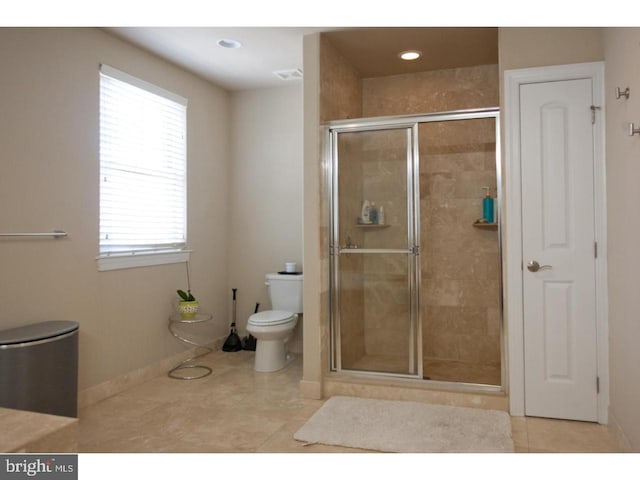 bathroom with tile patterned flooring, walk in shower, and toilet