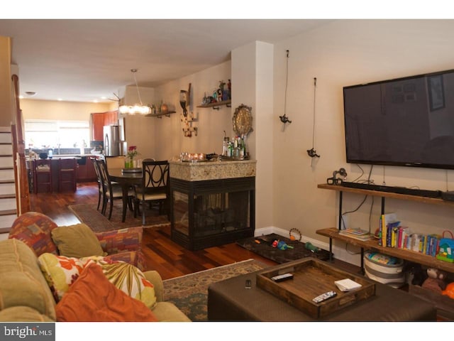 living room with a notable chandelier and dark hardwood / wood-style floors