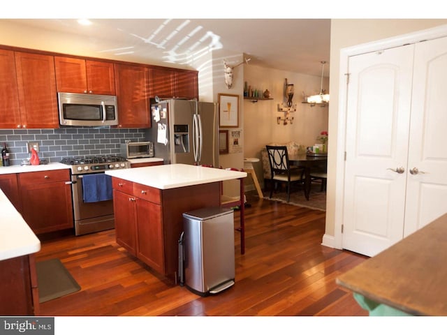 kitchen with a center island, backsplash, dark hardwood / wood-style floors, and stainless steel appliances