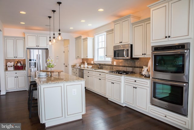 kitchen with backsplash, a center island, dark wood-type flooring, and stainless steel appliances