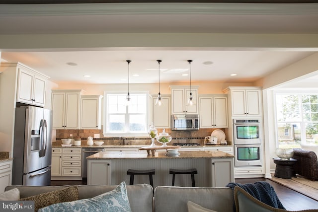 kitchen featuring appliances with stainless steel finishes, a kitchen bar, stone countertops, and backsplash