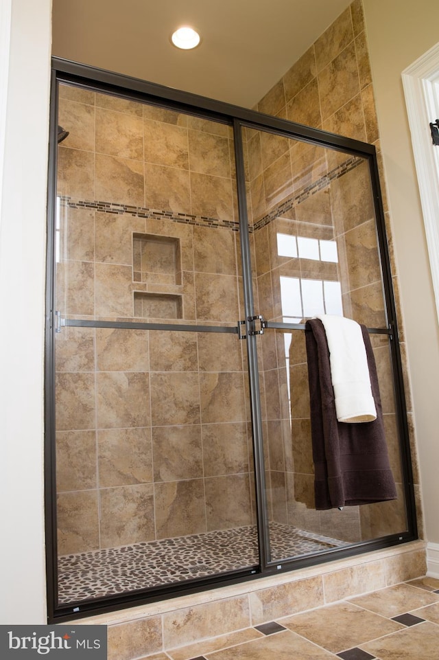 bathroom with a shower with door