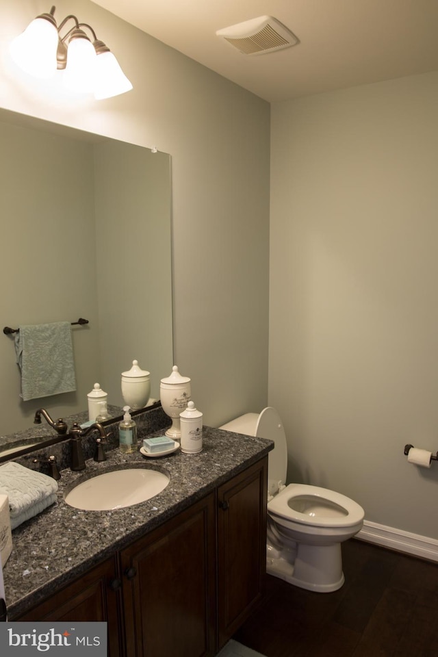 bathroom with wood-type flooring, toilet, and vanity