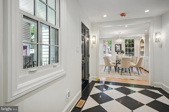 hallway with a notable chandelier and plenty of natural light