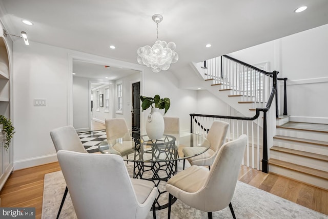 dining room featuring light wood-type flooring and a chandelier