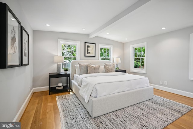 bedroom featuring vaulted ceiling with beams and hardwood / wood-style floors