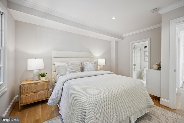 bedroom with connected bathroom, ornamental molding, and hardwood / wood-style floors