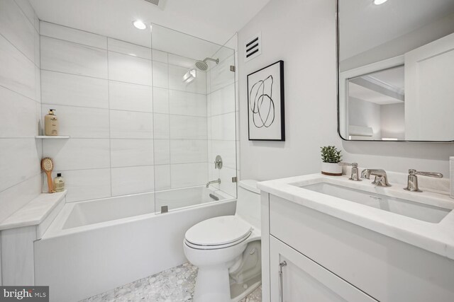 full bathroom featuring tiled shower / bath combo, vanity, and toilet