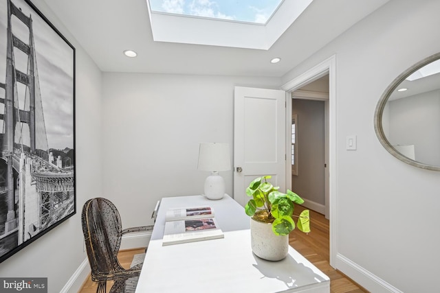 office space featuring hardwood / wood-style floors and a skylight