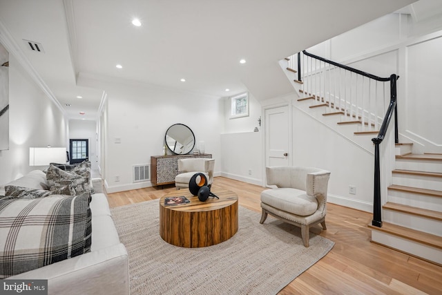 living room featuring light hardwood / wood-style flooring and ornamental molding