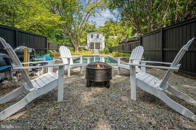 view of yard featuring a fenced in pool and a fire pit