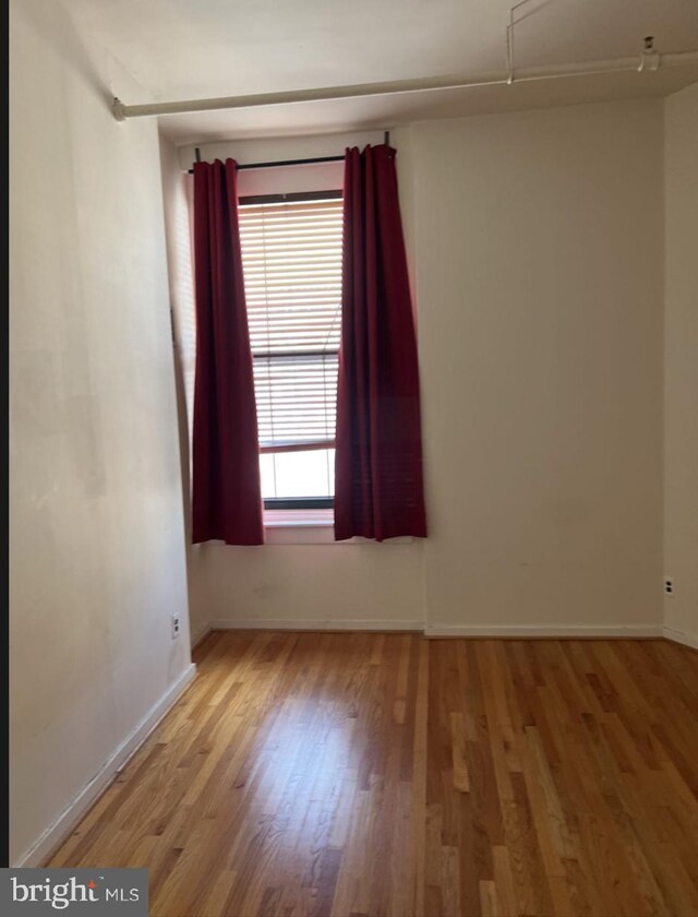 unfurnished room with wood-type flooring