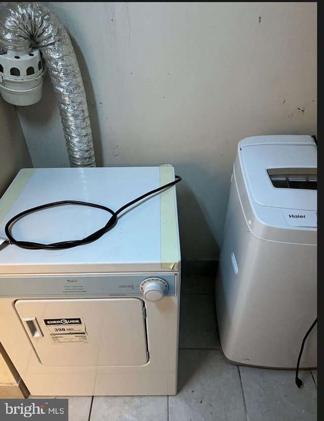 washroom with washer / dryer and light tile patterned floors