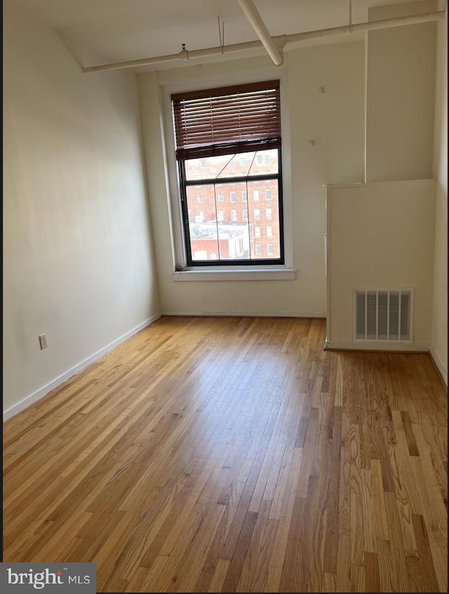 empty room with light hardwood / wood-style flooring