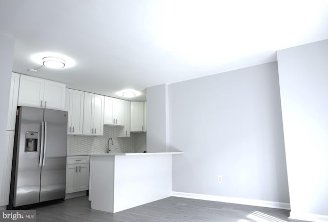 kitchen with stainless steel fridge, tasteful backsplash, dark wood-type flooring, and white cabinets