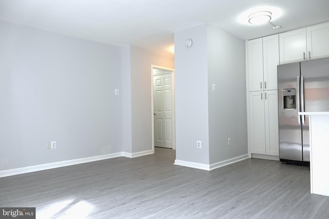 kitchen featuring wood-type flooring, white cabinets, and stainless steel fridge with ice dispenser