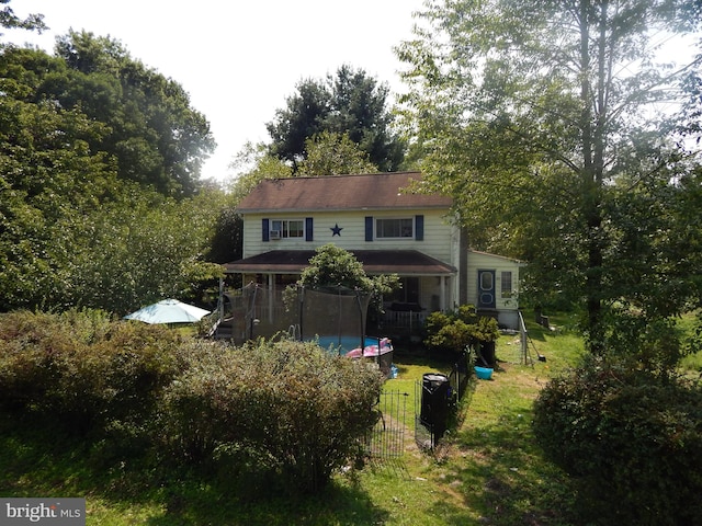 view of front of property with a fenced in pool and a front lawn