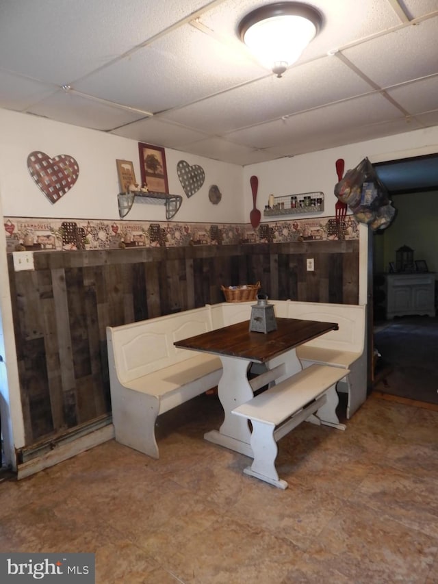 dining room with tile patterned flooring and a drop ceiling